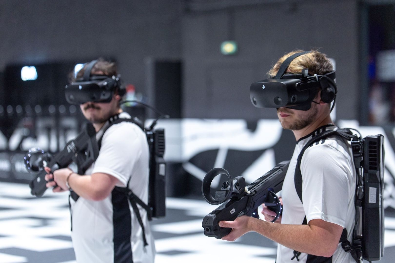 Två personer spelar VR med headset och rörelsekänsliga gevär